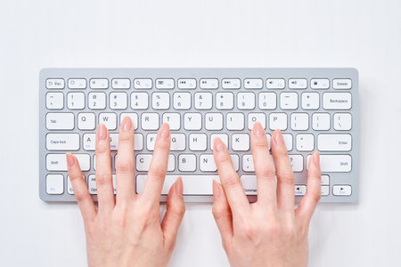 Hands of a woman typing on a keyboardの写真素材