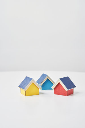 Models of multiple houses lined up on a white tableの写真素材