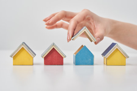Models of multiple houses lined up on a white tableの写真素材