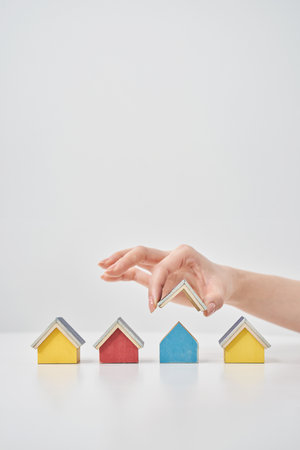 Models of multiple houses lined up on a white tableの写真素材