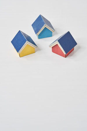 Models of multiple houses lined up on a white tableの写真素材