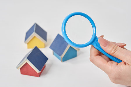 Magnifying glass pointed at a house model on the tableの写真素材
