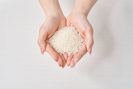 A cup of rice in the hand and white backgroundの写真素材