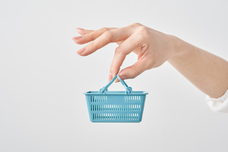 Hand of a woman holding a small shopping basketの写真素材