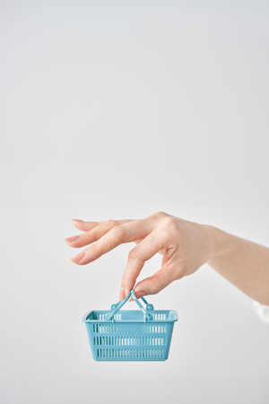 Hand of a woman holding a small shopping basketの写真素材