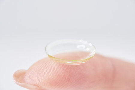 woman's fingers with contact lenses and white backgroundの写真素材