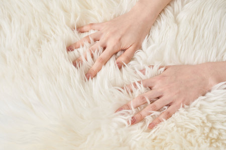 A woman's hand touches the fluffy fabricの写真素材