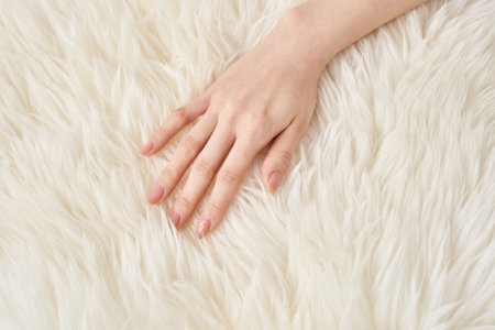 A woman's hand touches the fluffy fabricの写真素材