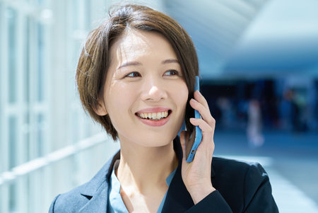 Smiling woman talking on smartphoneの写真素材