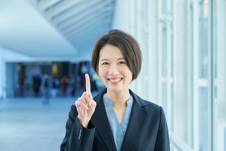 A business woman smiling and raising her index fingerの写真素材