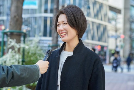 Middle-aged woman being interviewed on the streetの写真素材