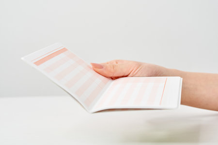 Woman's hand looking at bank passbook and white backgroundの写真素材