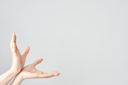Palms of a woman's hands open upwards and white backgroundの写真素材