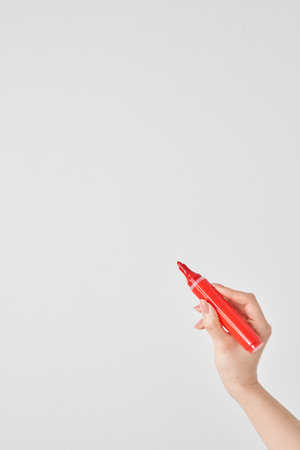 Woman's hand holding red magic pen and white backgroundの写真素材