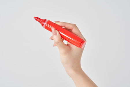 Woman's hand holding red magic pen and white backgroundの写真素材