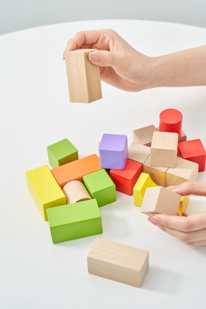 Hands of a woman stacking wooden blocks and white backgroundの写真素材