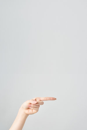 Woman's index finger pointing to the side and white backgroundの写真素材