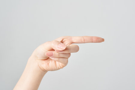 Woman's index finger pointing to the side and white backgroundの写真素材