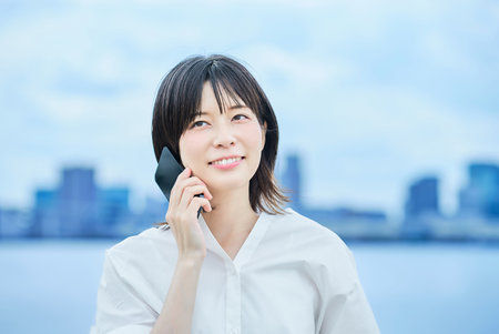 Young woman talking on smartphone outdoorsの写真素材