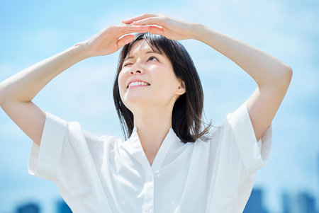 Young woman looking up at the sky on a sunny dayの写真素材