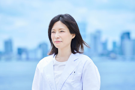 Young woman wearing a white coat outdoorsの写真素材