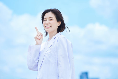 Young woman wearing a white coat outdoorsの写真素材