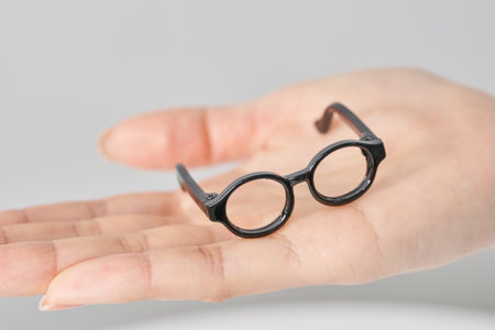 A model of glasses resting on a woman's palm and white backgroundの写真素材