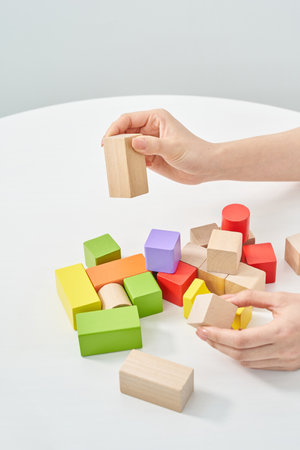 Hands of a woman stacking wooden blocks and white backgroundの写真素材