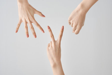 Hands playing rock, paper, scissors and white backgroundの写真素材