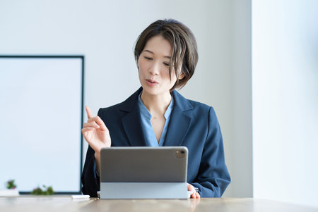 Middle-age woman in a suit during an online meetingの写真素材
