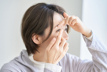 Woman wearing contact lenses indoorsの写真素材