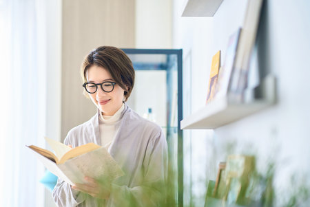Middle-aged woman reading in her room