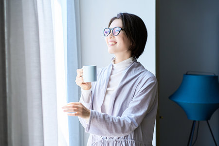A middle aged woman smiling in the morning lightの写真素材