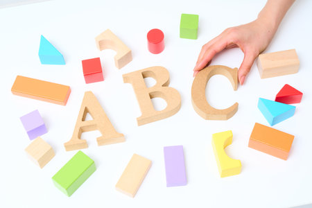 Colorful building blocks and wooden alphabet blocks arranged with the letters ABC and White...
