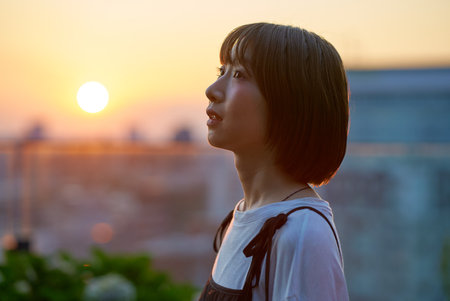 Portrait of a young woman standing in the city during magic hour