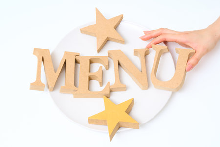 Wooden alphabet blocks arranged with the word "MENU" and white backgroundの写真素材