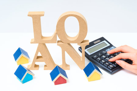Wooden alphabet blocks arranged with the word "LOAN" and white backgroundの写真素材