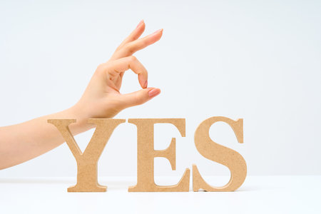 Wooden alphabet blocks arranged to spell out YES and white background