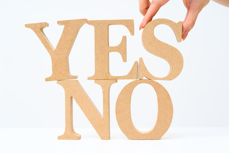 Wooden alphabet blocks arranged with the letters "YES" and "NO" and white backgroundの写真素材
