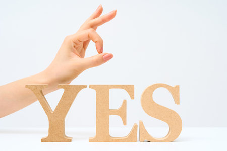 Wooden alphabet blocks arranged to spell out "YES" and white backgroundの写真素材