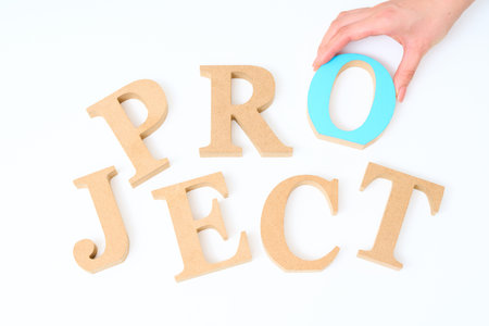 Wooden alphabet blocks arranged with the word "PROJECT" and white backgroundの写真素材