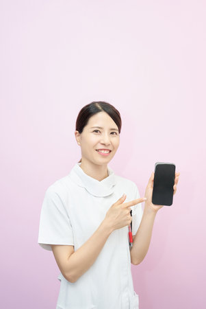 A young woman in a uniform operating a smartphoneの写真素材