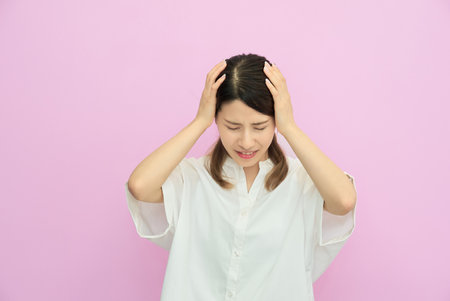 Young woman holding her head indoors