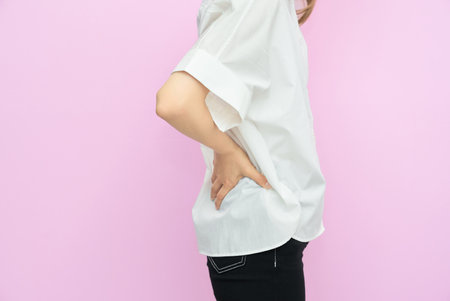 Woman suffering from back pain indoorsの写真素材