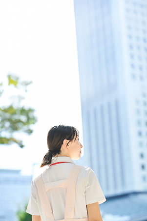 A young woman wearing a white coat and apron outdoorsの写真素材