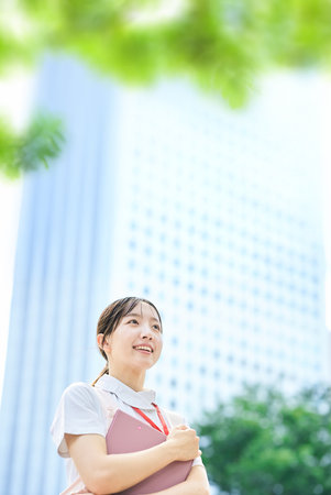 A young woman wearing a white coat and apron outdoorsの写真素材