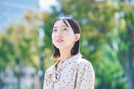 Portrait of a young woman relaxing in green spaceの写真素材