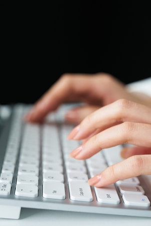 close up of hands typing on a computer keyboardの写真素材