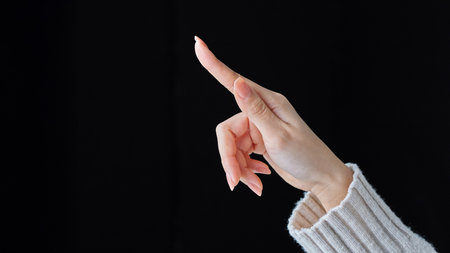 Touching gesture with index finger and black backgroundの写真素材