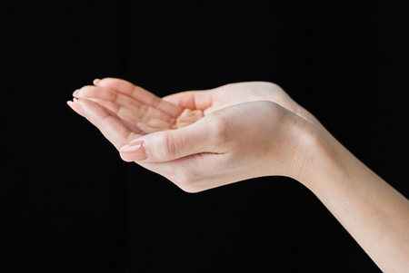 Scooping up with the palm of your hand and black backgroundの写真素材
